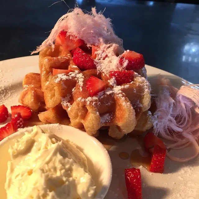 Belgium Waffles served with Canadian maple syrup, strawberries, passionfruit mascarpone and rose fairy floss